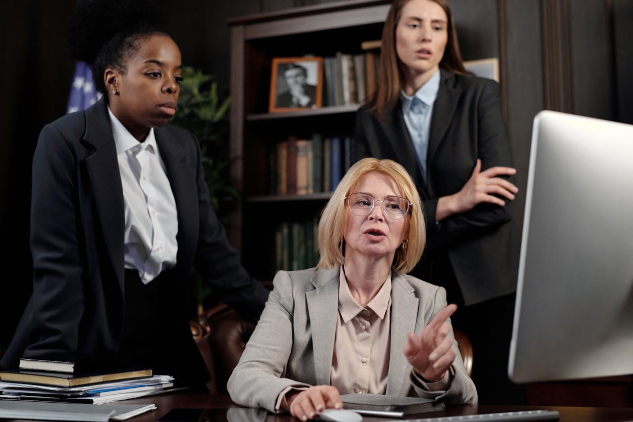 A group of diverse businesswomen collaborating in a modern office setting, discussing work strategies.